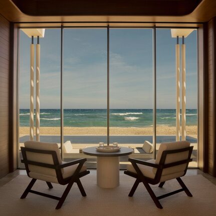 Beachfront casita at Amanvari with two chairs facing expansive sea views through floor-to-ceiling windows.